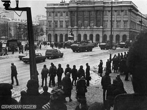 Polish policemen watch a demonstration near the University in Warsaw in December 1981.