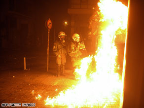 Riot police avoid being hit by a Molotov cocktail thrown by protesters in Athens.