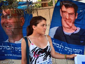 A Hezbollah militant in 2007 puts a flag on a billboard bearing photographs of two kidnapped Israeli soldiers.