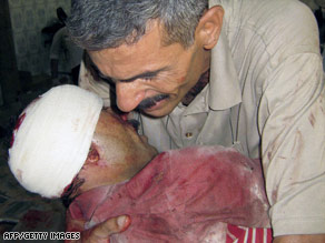 An Iraqi man hugs his brother who was wounded in Tuesday's suicide attacks in Baquba.