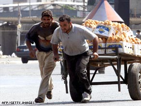 A potato vendor takes his cart and runs for cover during a clash Saturday in Tripoli, Lebanon.