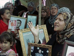 Palestinian women and children hold up framed portraits of relatives jailed in Israel.