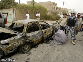 An Iraqi checks the damage to his car from a car bomb in Baghdad on Monday.