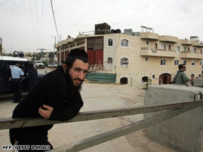 A Jewish settler stands Wednesday outside a disputed house in the West Bank city of Hebron.