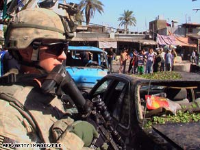 A U.S. soldier keeps watch at the scene of a suicide bombing in Baghdad, Iraq, this month.