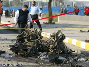 An Iraqi policeman inspects the scene of a car bombing near a police academy in Baghdad on Monday.