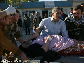 A wounded woman receives care after a suicide bombing Thursday outside Kirkuk, Iraq.