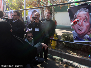 A woman throws a training shoe at a caricature poster of President George W. Bush in Tehran on December 26.