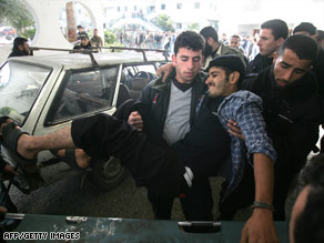 A wounded man is lifted onto a stretcher after arriving at Shifa Hospital in Gaza City on Sunday.