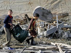 Palestinian boys carry their belongings over the ruins of a house Tuesday after an Israeli airstrike in Rafah.