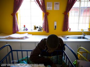 Jeremy Baker, 15, plays with an infant at the Ethembeni orphanage in Soweto, South Africa.