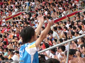  An Olympic volunteer leads cheers at the Bird's Nest during the women's marathon.