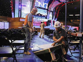 Electricians connect power cable as preparations on the floor of the site of the Democratic National Convention in Denver, Friday. The convention starts Monday, Aug. 25.