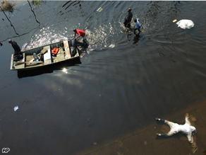 Hurricane Katrina victims bring a boat to help ferry people past a dead body outside the Louisiana Superdome in New Orleans 3 years ago