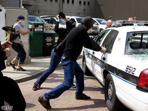 Protestors vandalize police cars in the streets outside the Republican National Convention at the Xcel Energy Center, Monday.