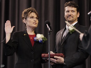 Todd Palin holds the Bible for his wife, Sarah Palin, as she is sworn in as Alaska's governor in Fairbanks, Alaska, Dec. 4, 2006.