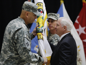 US Defense Secretary Robert Gates hands over the Multi-National Force Iraq flag Gen. Ray Odierno while outgoing commander Gen. David Petraeus looks on during a Change of Command ceremony at camp Victory in Baghdad, Iraq