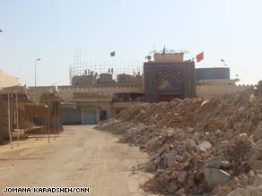 View of the al-Askari Shrine missing the golden dome and rubble on side of the road.