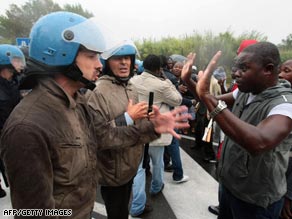 Police at a protest against the killing of six immigrants near Naples.