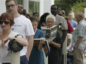 People stand in line to vote early Wednesday in Pompano Beach, Fla. Unprecedented numbers of early voters in the South are prompting local election officials to take measures to make people comfortable as they wait for hours to cast their ballots.