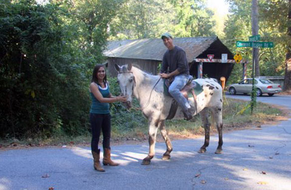 Brett crossing a covered bridge on a horse