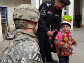 An Iraqi schoolgirl tries on her new backpack.