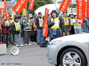 Honda workers protest Tuesday's production cuts outside the car company's HQ in Tokyo.