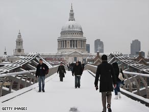 Pedestrians cross the Thames in front of St Paul's Cathedral in London's financial district.