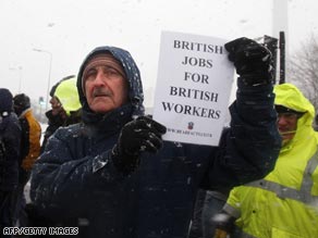 A policeman watches protesters at Lindsay during a heavy snowfall Tuesday.
