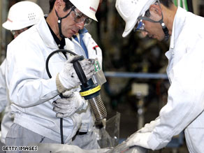 Employees of Nissan Motor Company work on the assembly line in Japan.