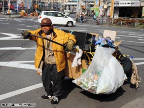 A homeless man pulls his cart filled with possessions and goods for recycling on March 18 in Osaka, Japan.