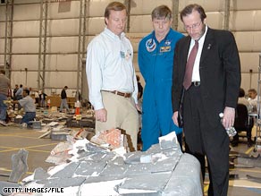 Courtney Stadd, right, is seen examing debris from the Space Shuttle Columbia break-up in 2003.