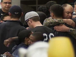 Officers console each other outside the Oakland hospital where their colleagues are in critical condition.