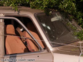 Bullet holes pocked the windshield of the crashed SUV, and blood stained he passenger seat.