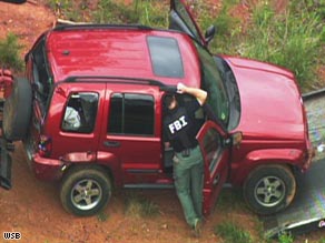 Authorities examine a Jeep belonging to professor George Zinkhan on May 1 in Clarke County, Georgia.