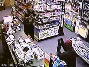 Surveillance video shows storekeeper Mohammad Sohail holding a robber at bay with a shotgun.