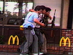 Police help a wounded customer out of a California McDonald's where a man killed 21 people in 1984.