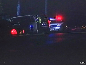 Police officers stand patrol outside the Gee household late Monday evening.