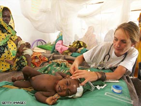 A doctor with Médecins Sans Frontières (Medics without Borders) helps a sick child in a Darfur refugee camp.