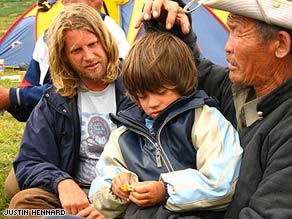 Ghoste, a shaman, works on Rowan while his father watches.