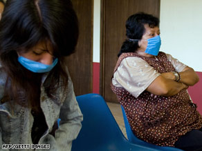 Women wearing masks wait at a health clinic Saturday in Mexico City.