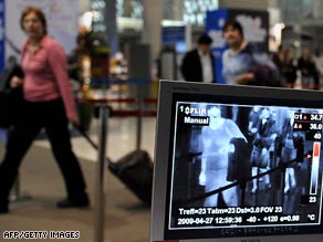 Quarantine officers monitor arrivals with a thermographic device at Bangkok's main international airport.