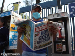 A man wearing a protective mask reads a newspaper Sunday outside a hospital in Mexico City.