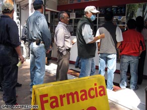 Concerned residents line up outside a pharmacy Monday in Mexico City, Mexico.