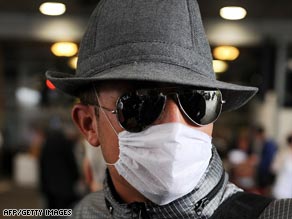 A passenger wears a face mask Thursday at Gatwick Airport in England on arrival from Mexico.