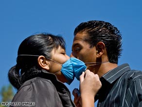 A couple kisses at a swine flu virus prevention and detection medical mobile unit in Mexico City.