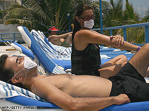 A passenger wears a face mask Thursday at Gatwick Airport in England on arrival from Mexico.