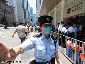 A policeman guards a Hong Kong hotel where 300 people are under quarantine.