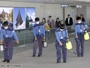 Workers in South Korea, where one case of swine flu is confirmed, disinfect a terminal Sunday at Incheon airport.