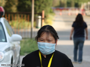 A worker walks outside a Chinese hotel where officials have quarantined visitors as a precaution against swine flu.